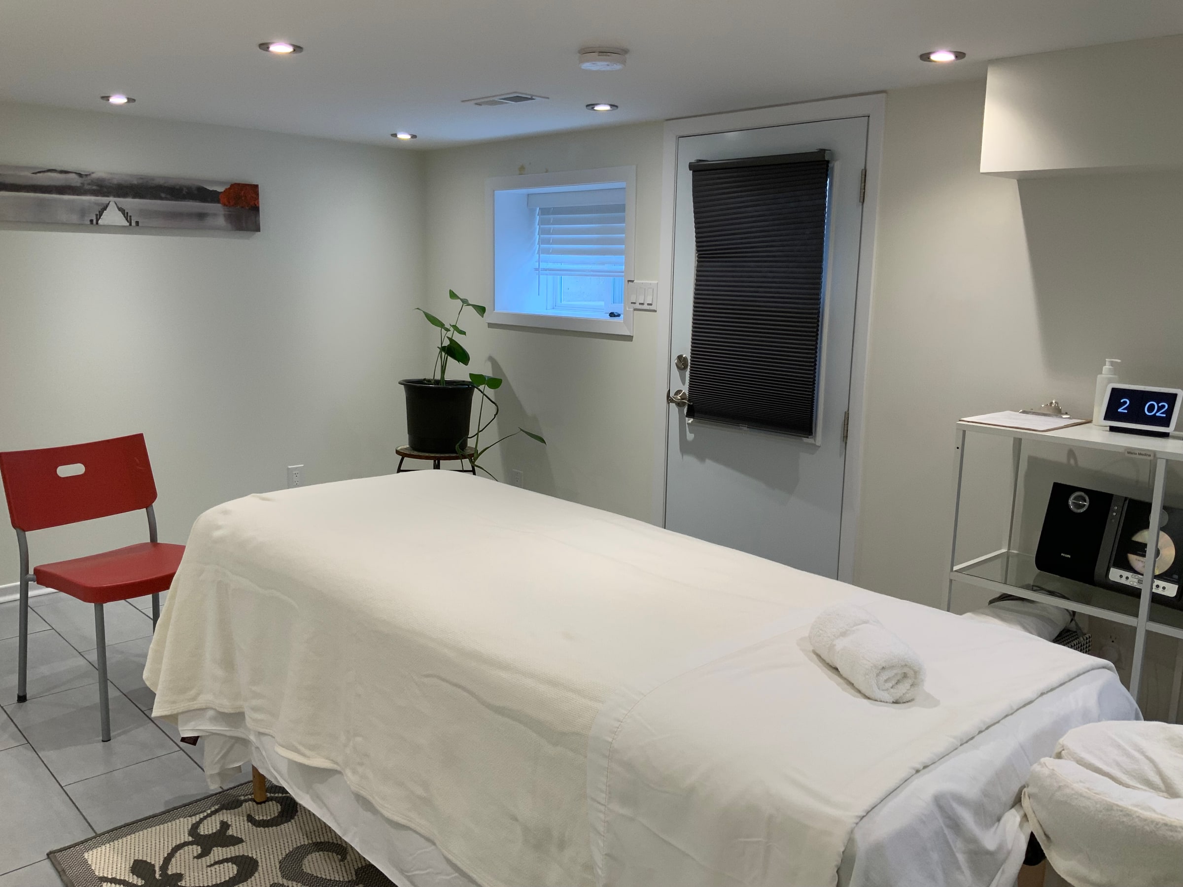 Massage table and seating in the treatment room at Cypri Massage Therapy, Toronto